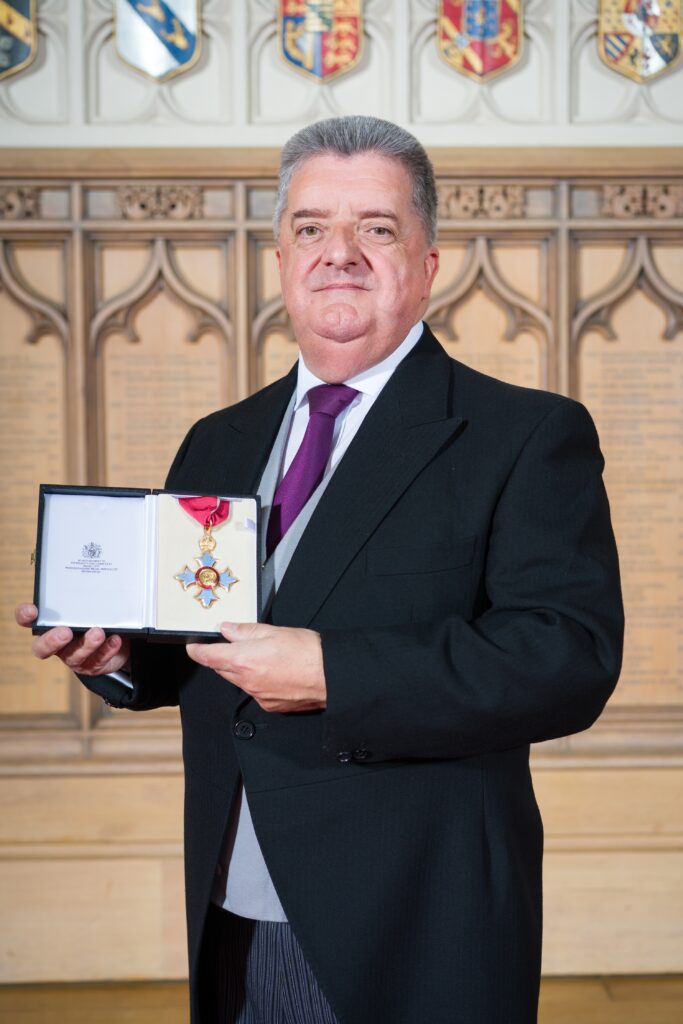 Ronnie Armour holding his CBE
